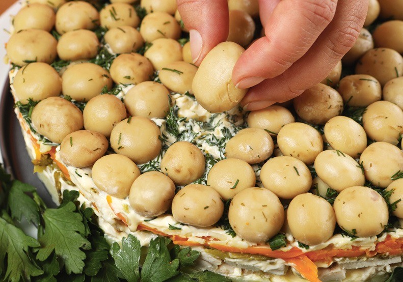 Сверху выложить оставшуюся курицу. Посолить, приправить. Смазать майонезом и посыпать рубленым укропом.  Воткнуть шляпки грибов.