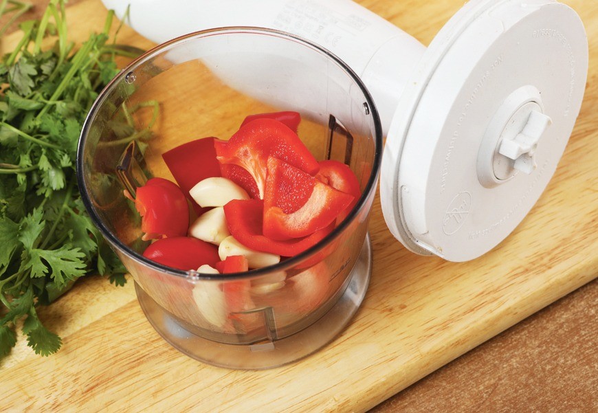 Чеснок и сладкий перец измельчить в блендере. Кинзу вымыть, обсушить и мелко нарезать.