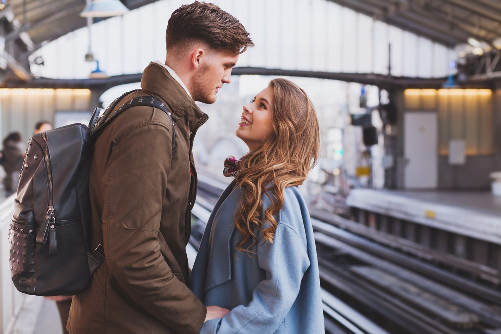 На расстоянии друг от друга. Пара на вокзале. Девушка провожает парня. Встреча на вокзале влюбленных. Мужчина и женщина на вокзале.
