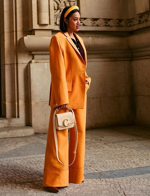 Лаконичный комплект из оранжевого однотонного костюма-двойки и бежевой сумки Chloe. Нам очень нравится как гармонируют между собой теплые оттенки оранжевого и бежевого.