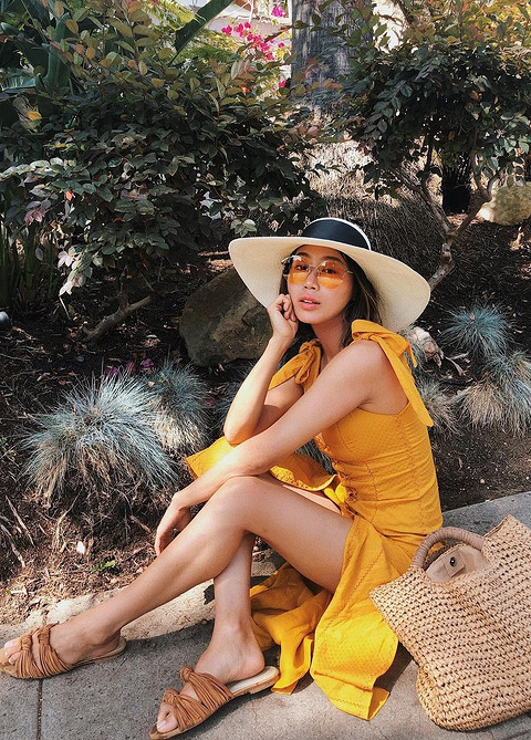Формула стильно летнего образа: желтое платье миди, плетеная шляпа с широкими полями и декоративной черной лентой. Модный блогер Эйми Сонг добавила также к этому комплекту коричневые текс...