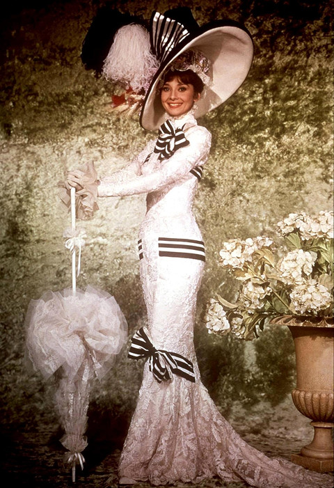 Еще один легендарный наряд из фильма «Моя прекрасная леди» (1964) — кружевное платье и огромная шляпа с объемными полосатыми бантами, в котором по сценарию картины героиня Одри пришла на...