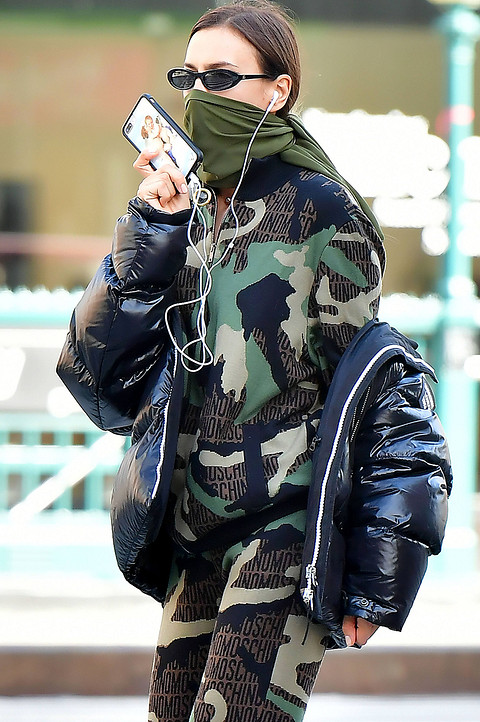 Ирина Шейк ходит по улицам Нью-Йорка в прямом смысле в униформе солдата. Модель предпочла удобный спортивный костюм Moschino с камуфляжным принтом, черную дутую куртку и темные узкие очки...